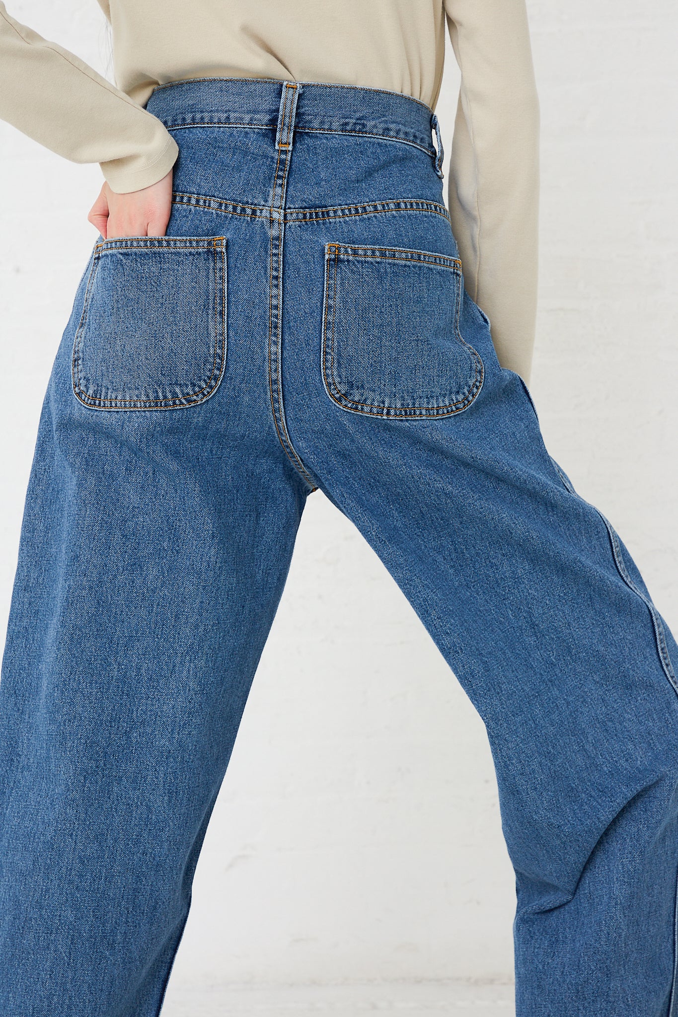 A woman effortlessly rocks a pair of high waisted jeans crafted from premium Japanese denim (Japanese Denim California Wide in Cowboy Blue by Jesse Kamm). Available at Oroboro Store.
