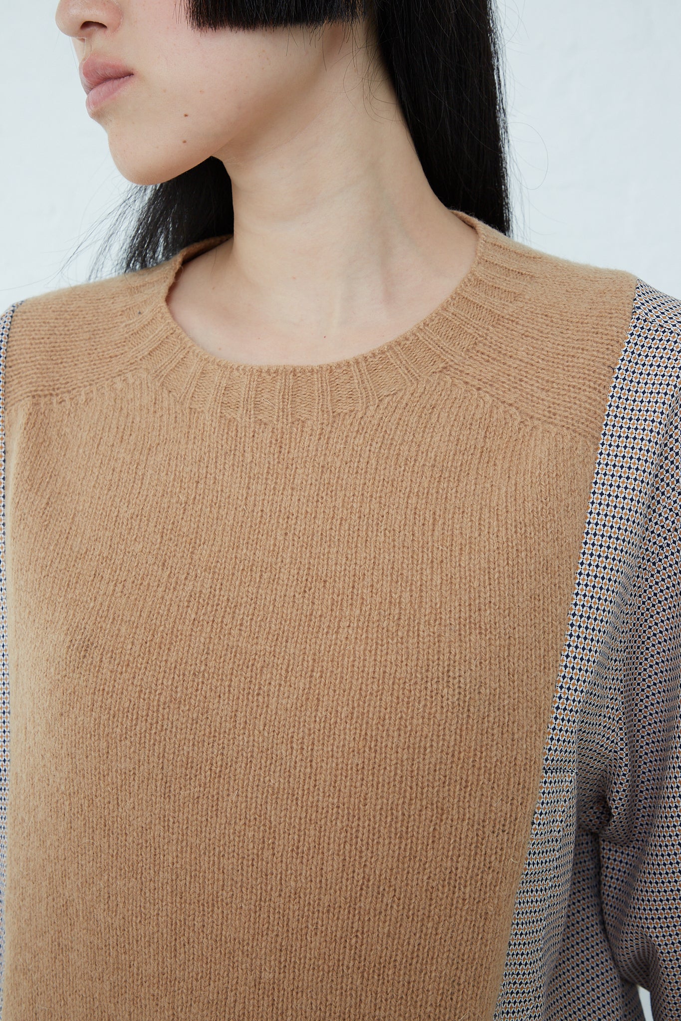 A woman wearing a Bless No. 68 Front Insert Pullover in Beige Pattern, in a camel sweater.