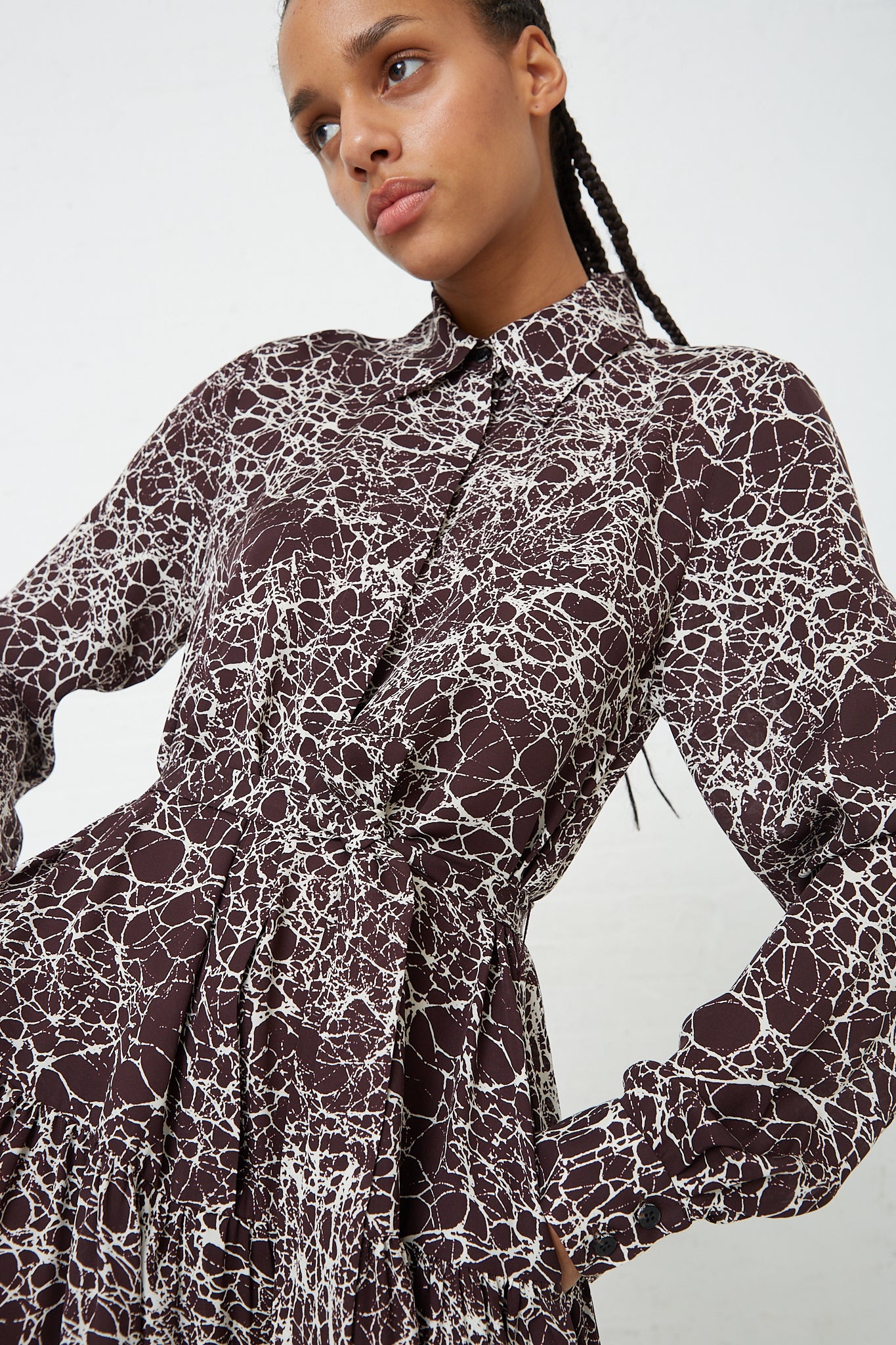 The model is wearing a long-sleeved Silk Marbled Georgette Jana Dress in Brown by Rachel Comey. Up close.