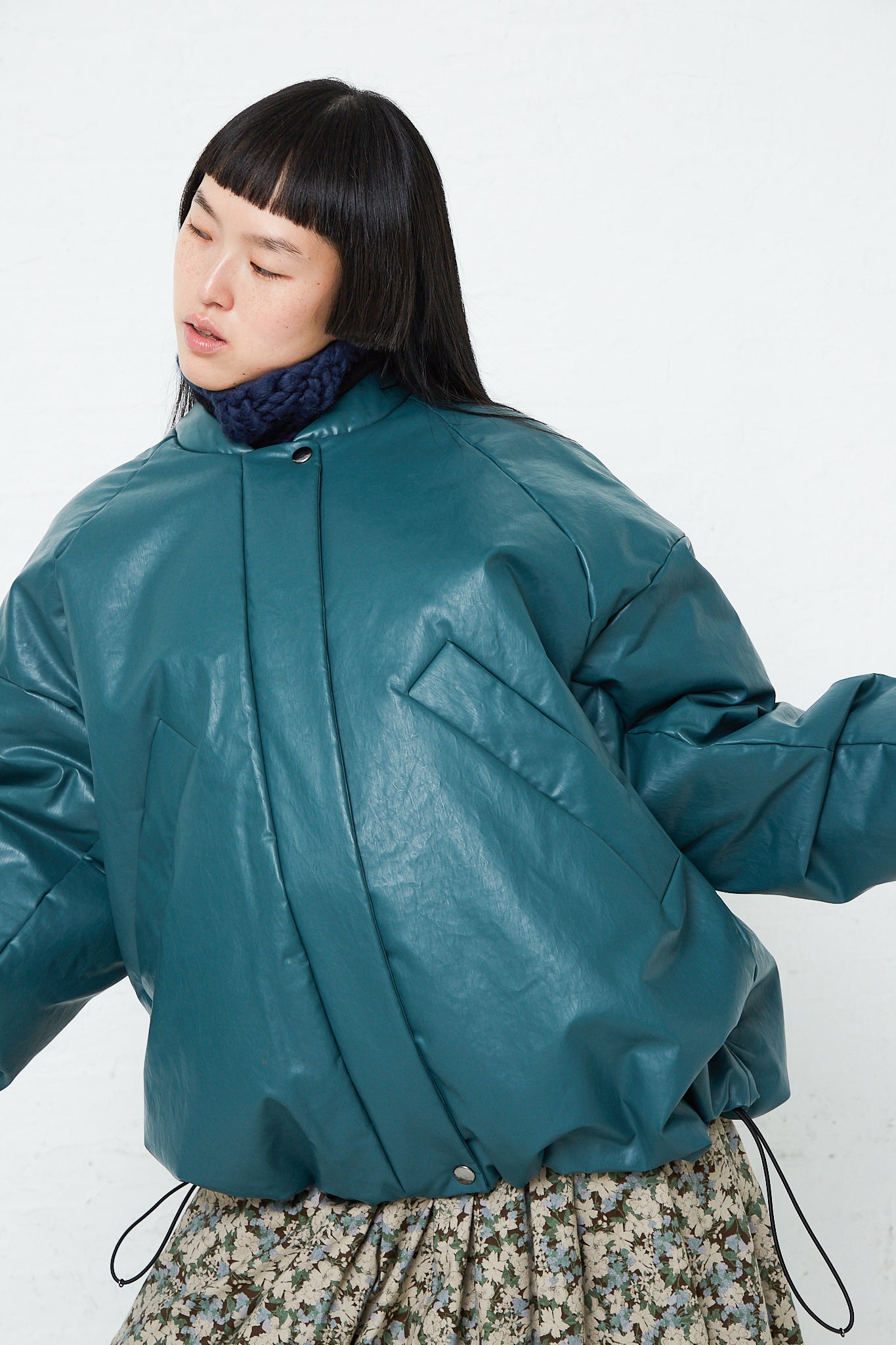 A woman in a Kassl Oversized Padded Bomber Oil Jacket in Forest. Available at Oroboro.