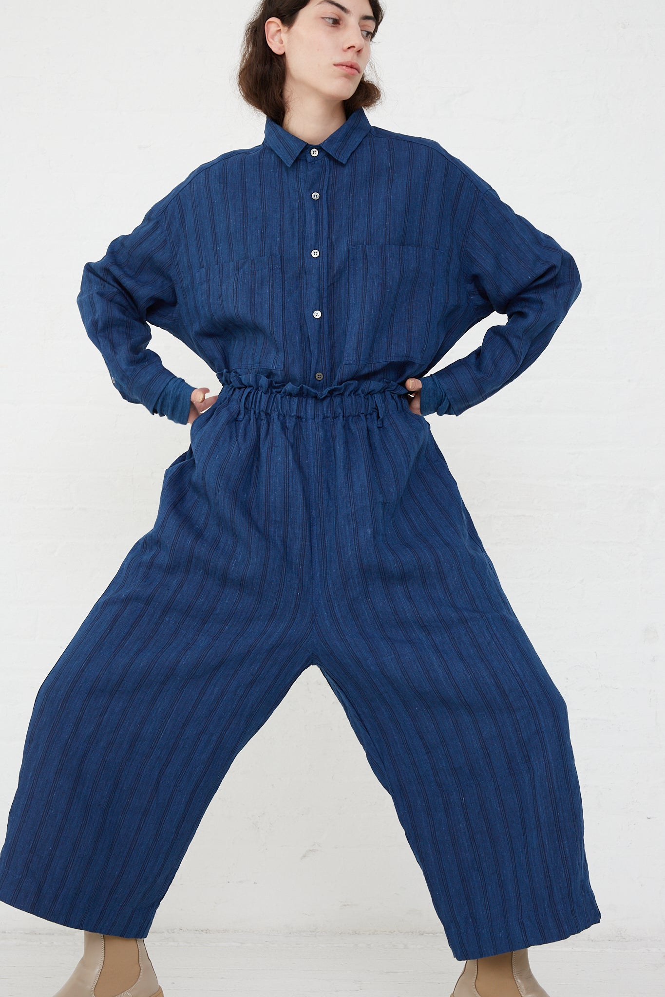 The model is wearing a Woven Linen Pant in Indigo Stripes by Ichi Antiquités with an elasticated waist and wide leg pants.