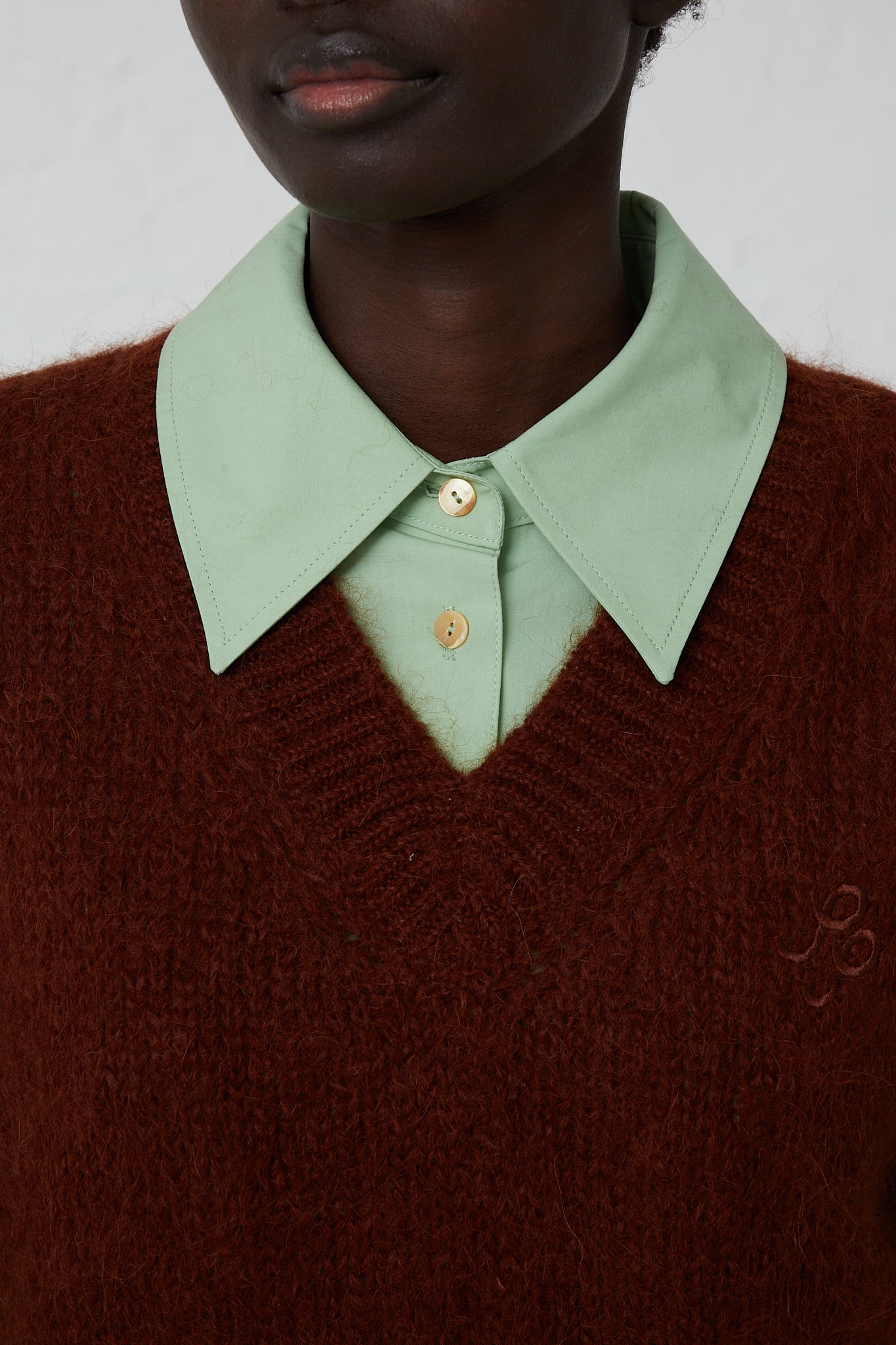 A woman wearing a Rejina Pyo Alpaca Blend Spencer Vest in Brown with a green collar.
