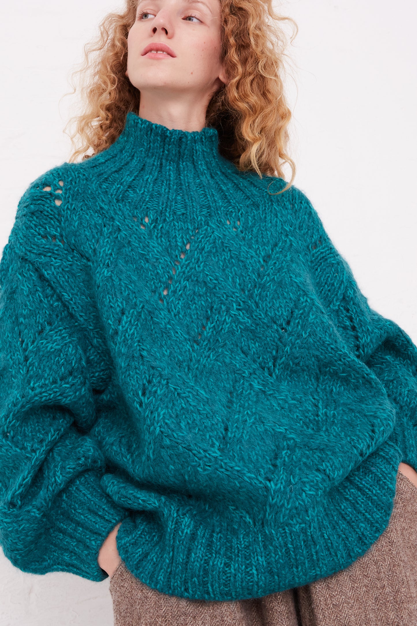 A woman wearing an oversized, Ichi Antiquités Hand-Knit Turtleneck in Green Teal sweater.