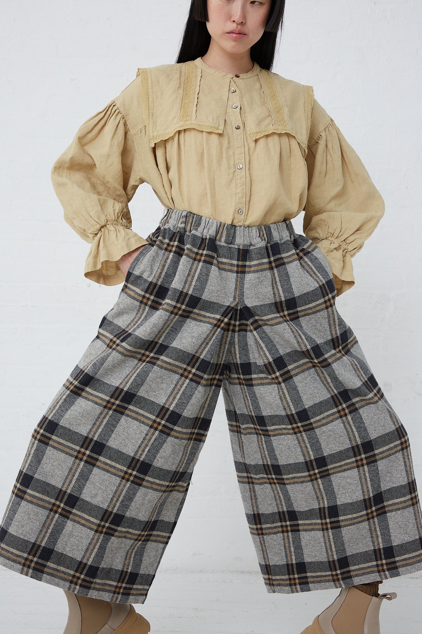 A woman wearing a yellow blouse and a pair of nest Robe's Cotton Heavy Twill Plaid Wide Leg Pant in Navy made of cotton twill.