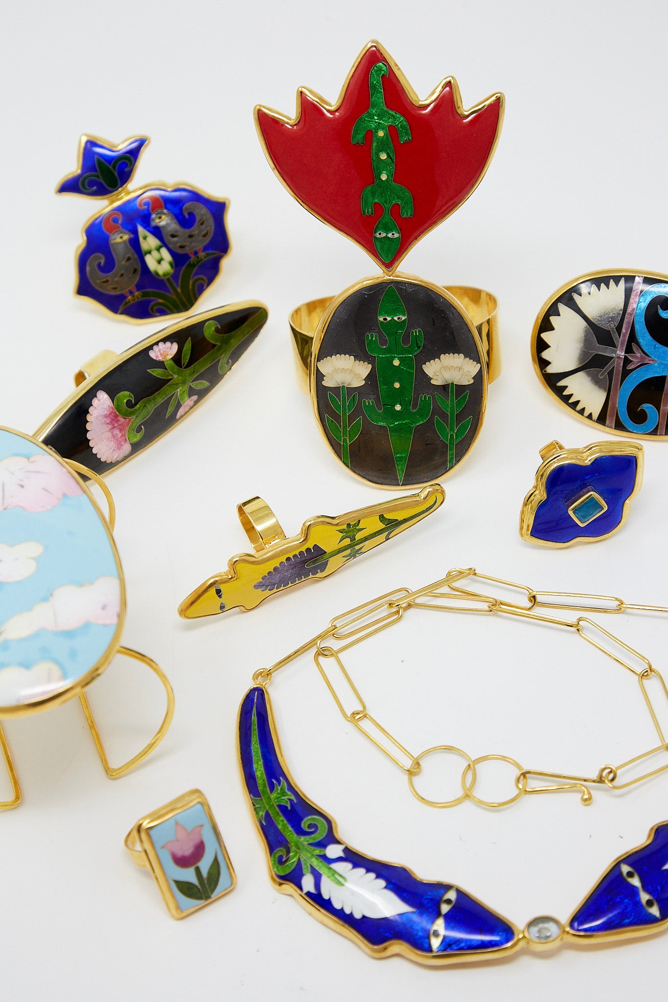 A collection of Sofio Gongli cloisonné technique gold jewelry with intricate enamel designs, including the Ring in Blue with Light Blue Center Square.