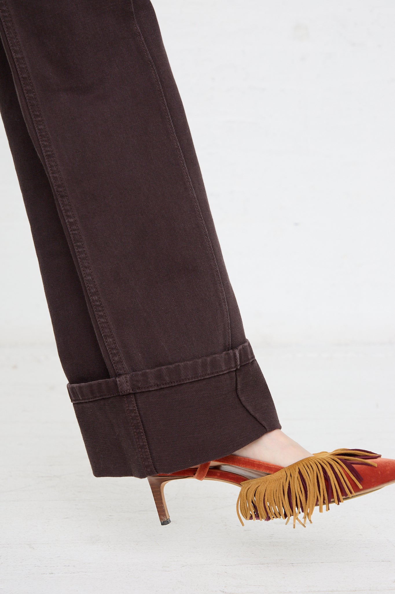 A woman's feet in a pair of Ulla Johnson's Genevieve Jean in Mahogany Wash with fringes.