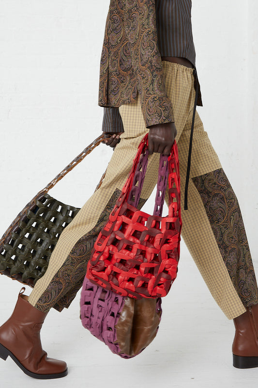 A woman is carrying a SC103 assortment of totes with woven patterns.