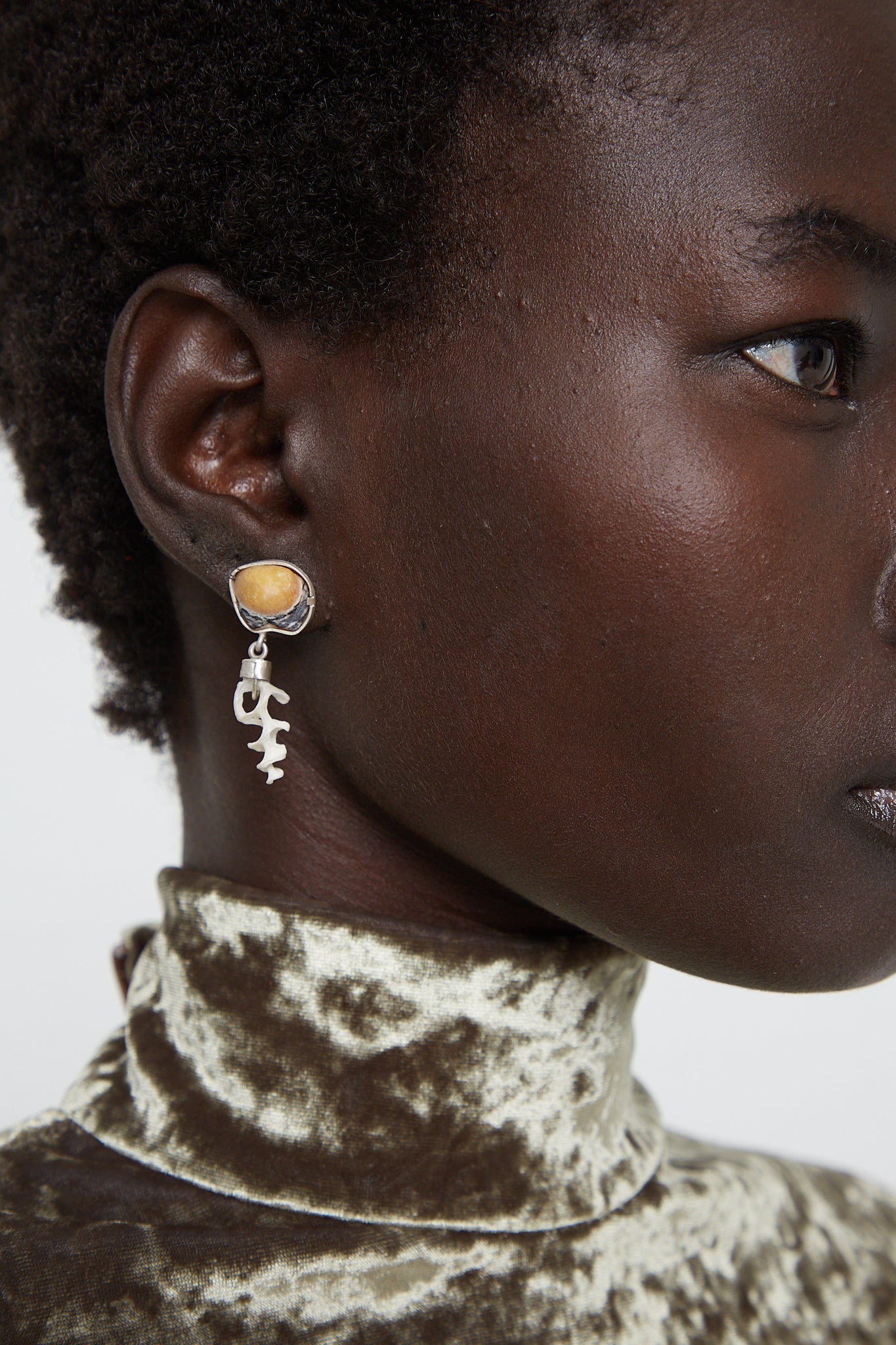 A black woman wearing La Mar's Sterling Silver Earrings 011 A with a yellow stone.