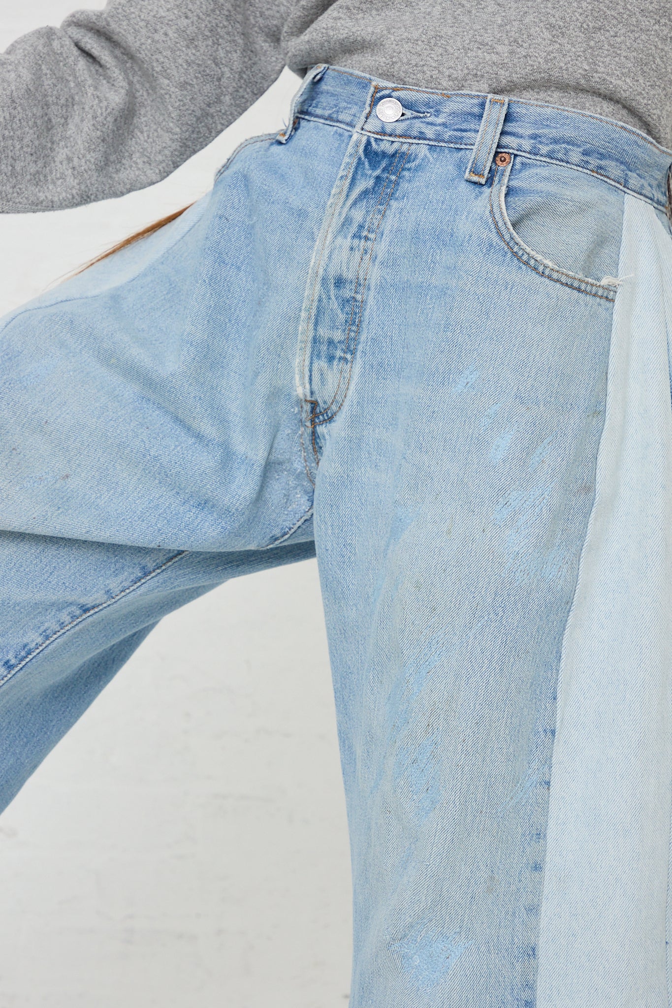 The woman is wearing a pair of B Sides Lasso Jean in Vintage Indigo with a cutoff frayed hem. Up close view.