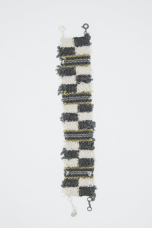A Stephanie Schneider Sterling Silver Oxidized Bracelet in Gold Plated and Silk with a graphic chain and a yellow stripe.