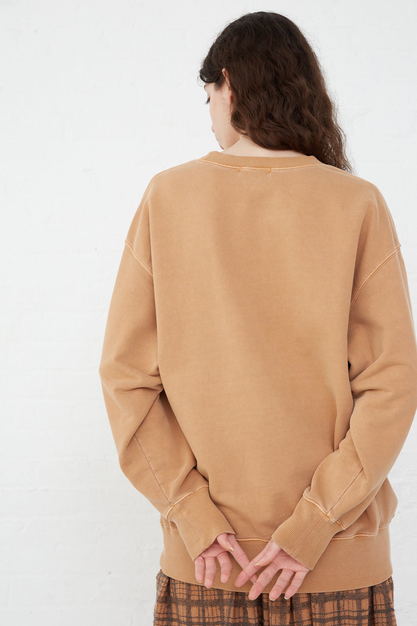 The back of a woman sporting an oversized fit Ichi Antiquités Pigment French Terry Cotton Pullover in Camel.