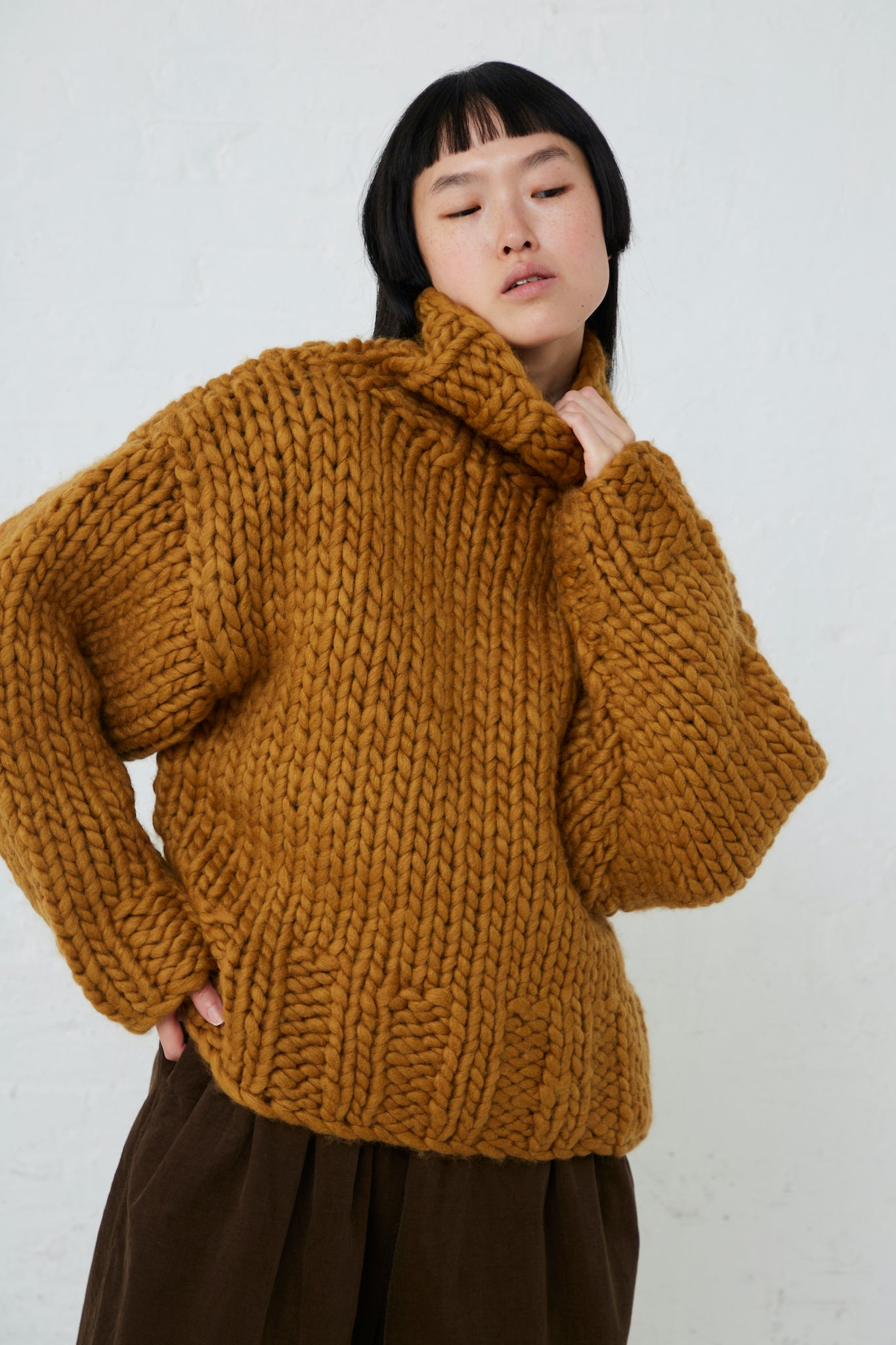 The model is wearing an Ichi Wool Hand-Knit Pullover in Mustard. Available at Oroboro Store.