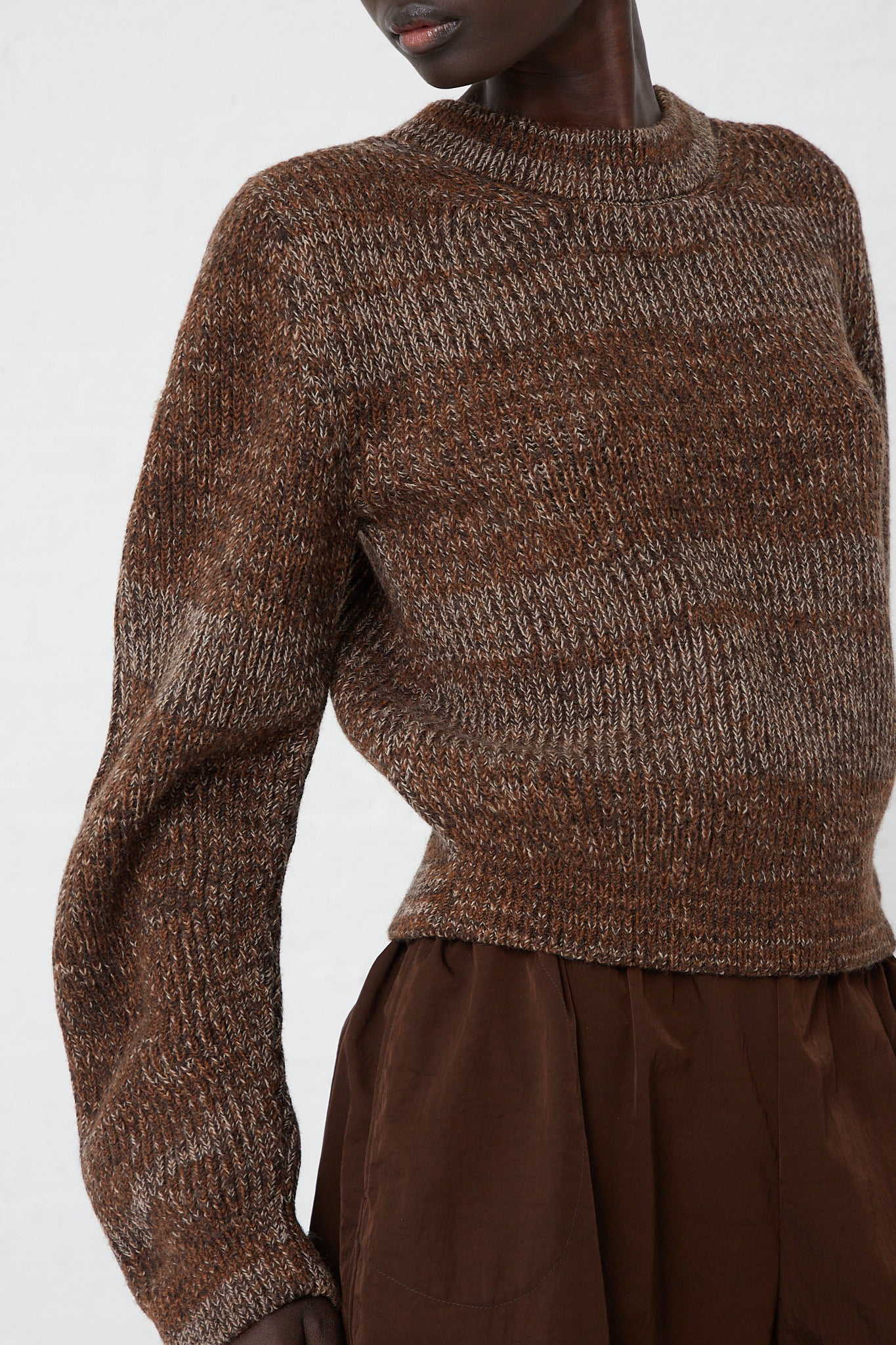 A model wearing a Curved Sleeve Sweater in Oak made by Veronique Leroy.