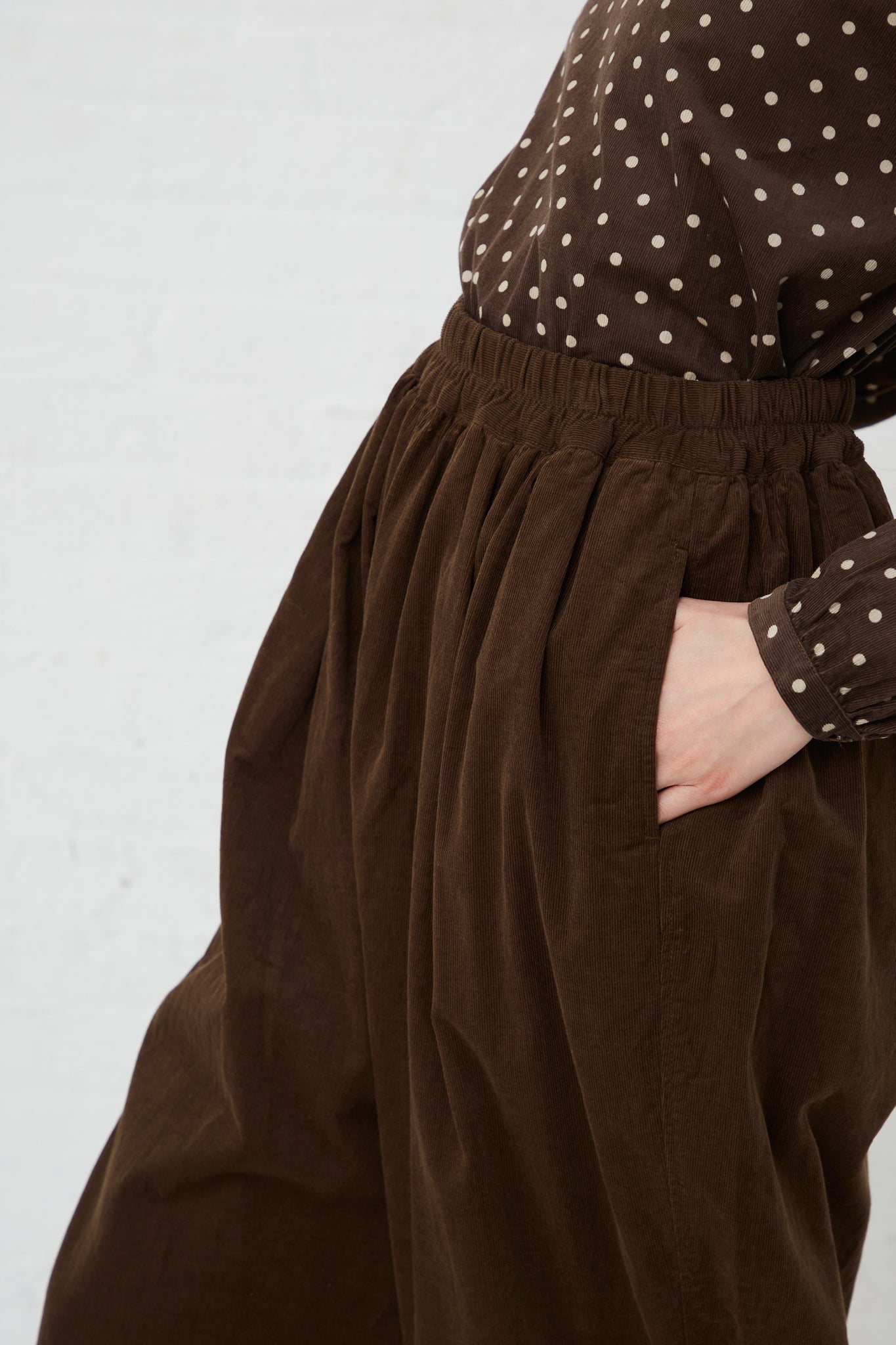 A woman wearing Ichi's Cotton Pant in Brown with a relaxed fit. Up close. Hand in pocket.