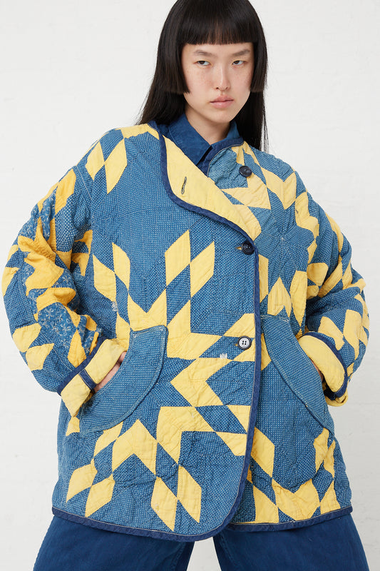 A woman wearing an As Ever Quilt Jacket in Indigo and Yellow.