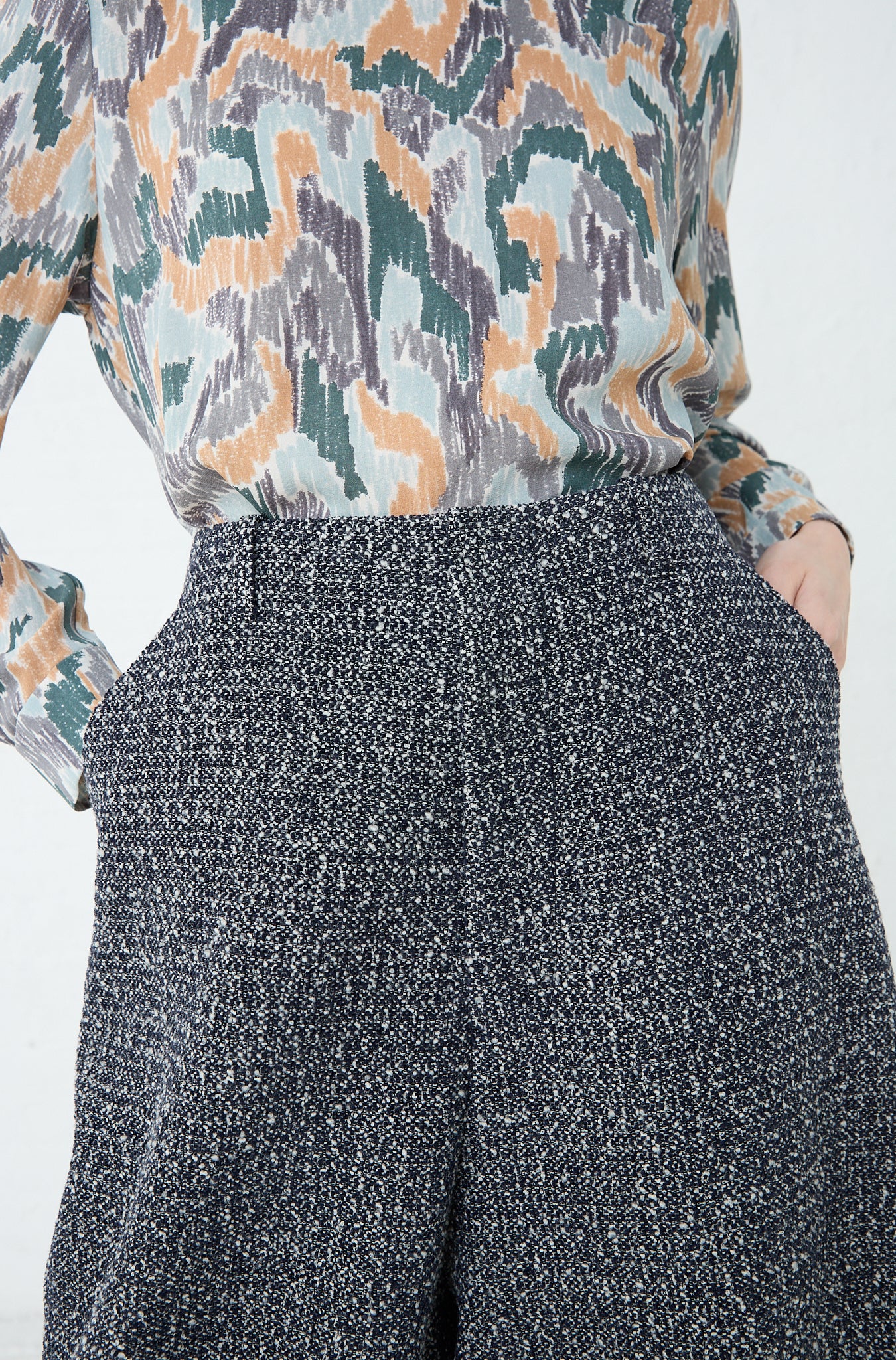 A woman wearing a Mina Perhonen Predawn Trouser in Navy Mix shirt and tweed shorts, both made in Japan, showcasing a relaxed fit. Front view and up close.