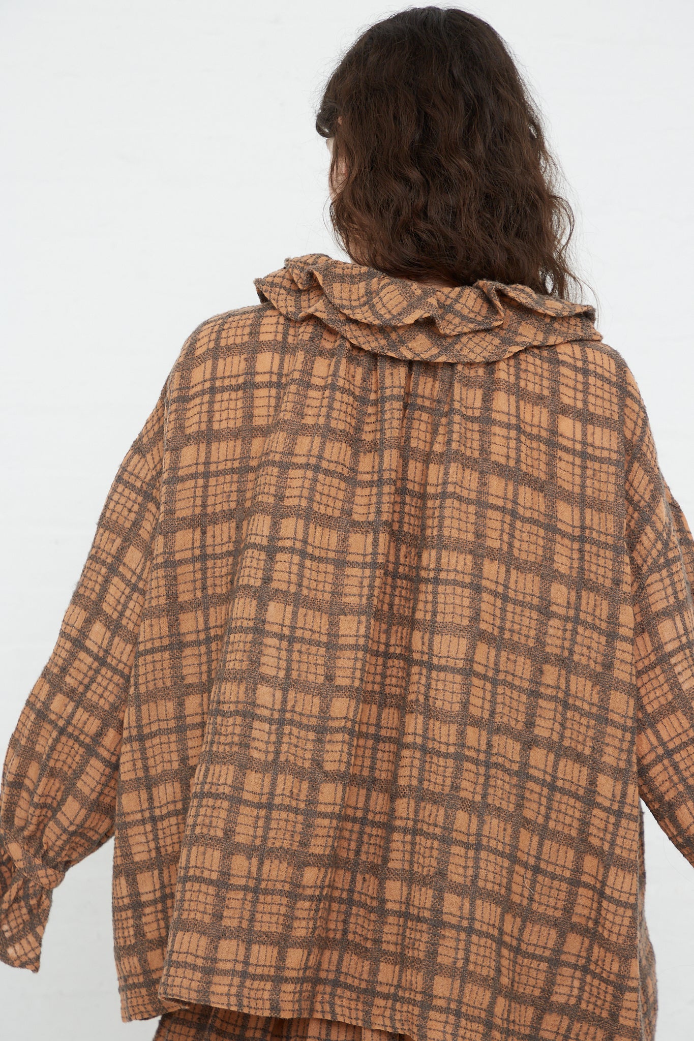 The back view of a woman wearing a Ichi Antiquités Wool Check Frill Blouse in Terracotta.