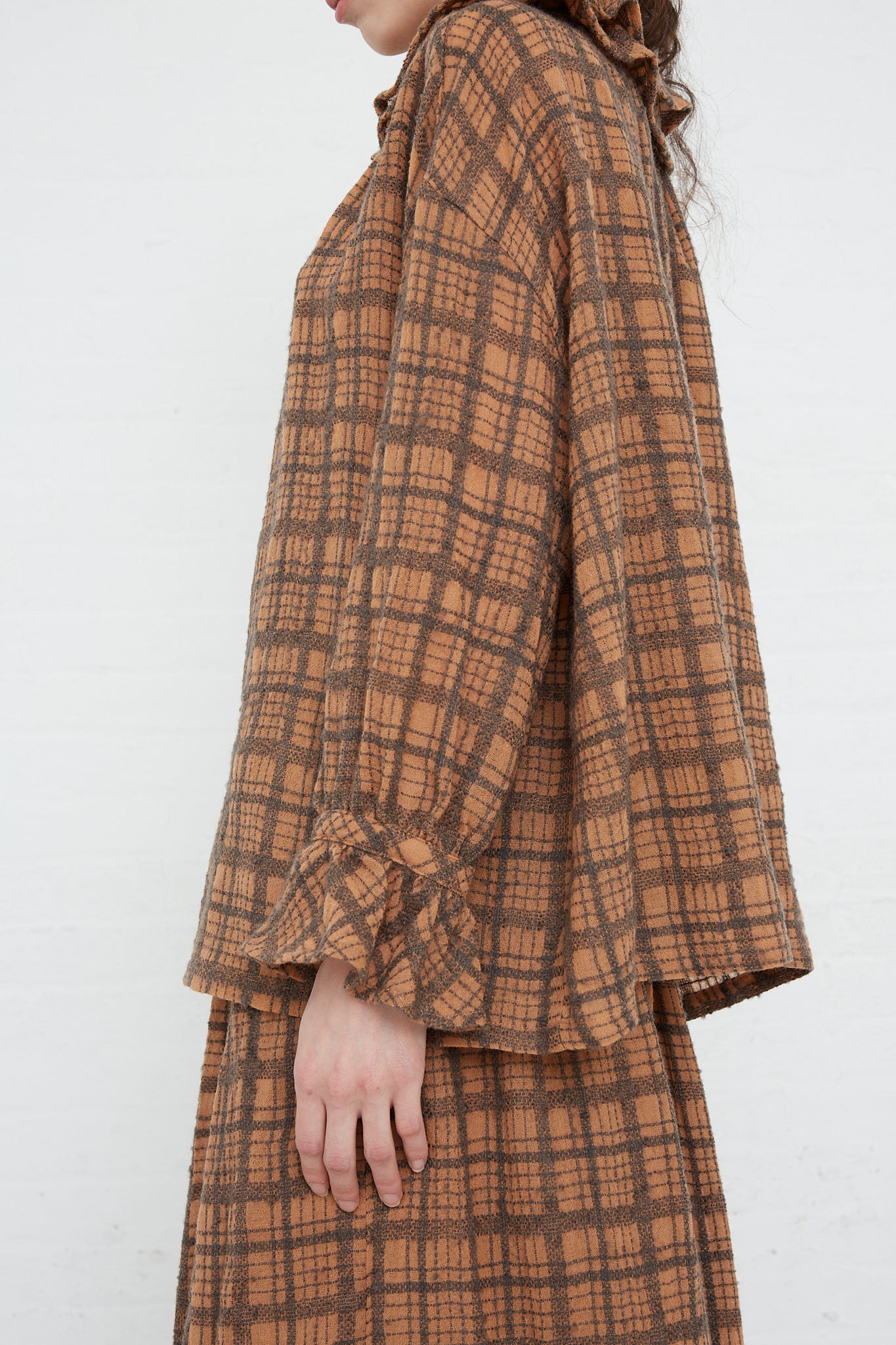 The back view of a woman wearing a Ichi Antiquités Wool Check Frill Blouse in Terracotta. Side view.