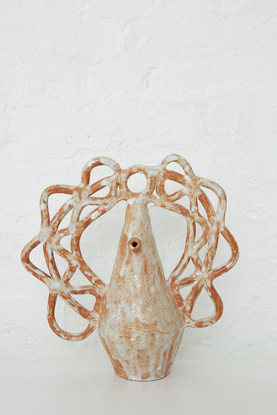 A Tall Botijo Bloom vase by Clandestine on a white table.