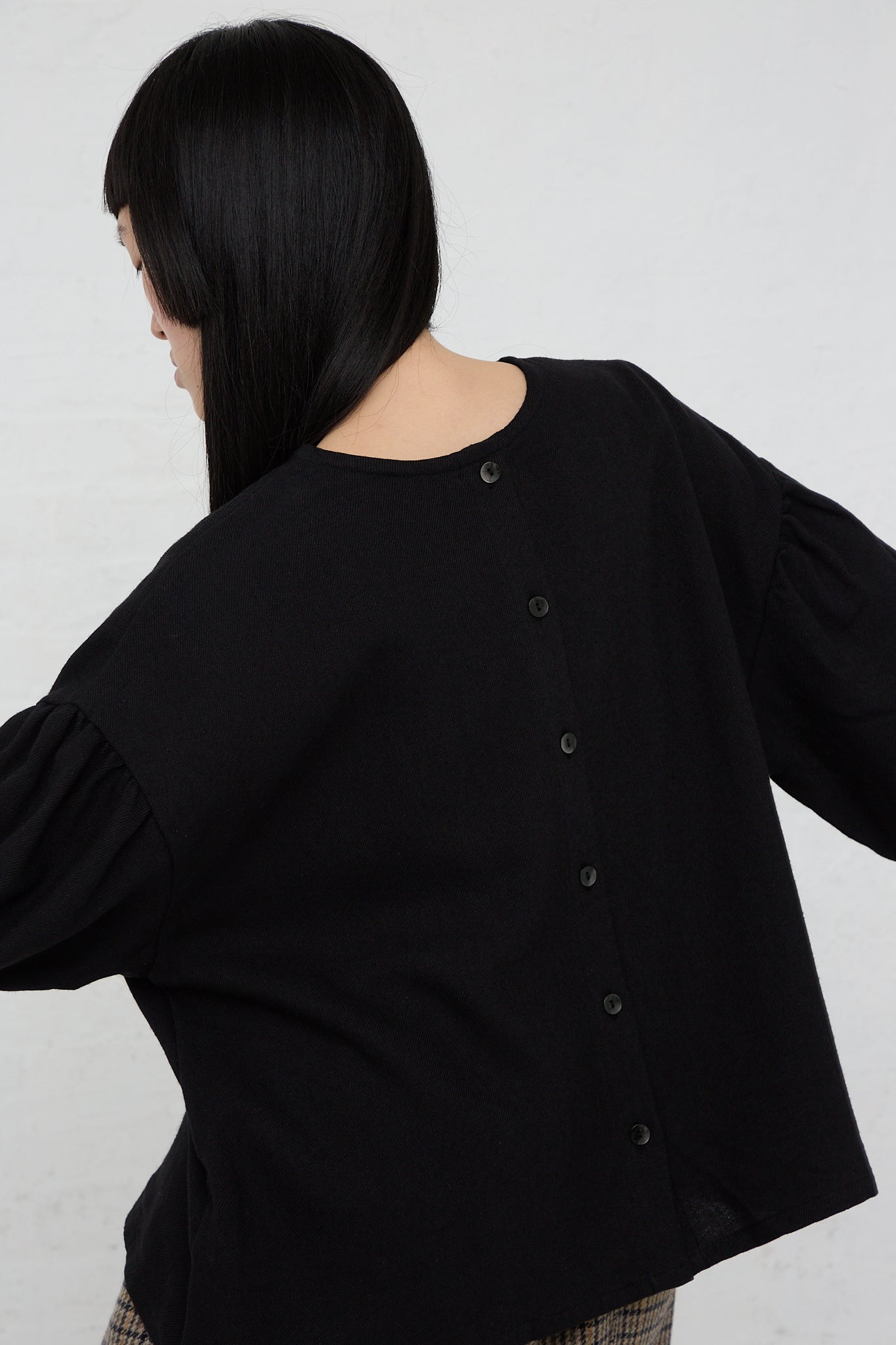 The back of a woman wearing an Ichi Two-Way Blouse in Black with puff sleeves and a relaxed fit.