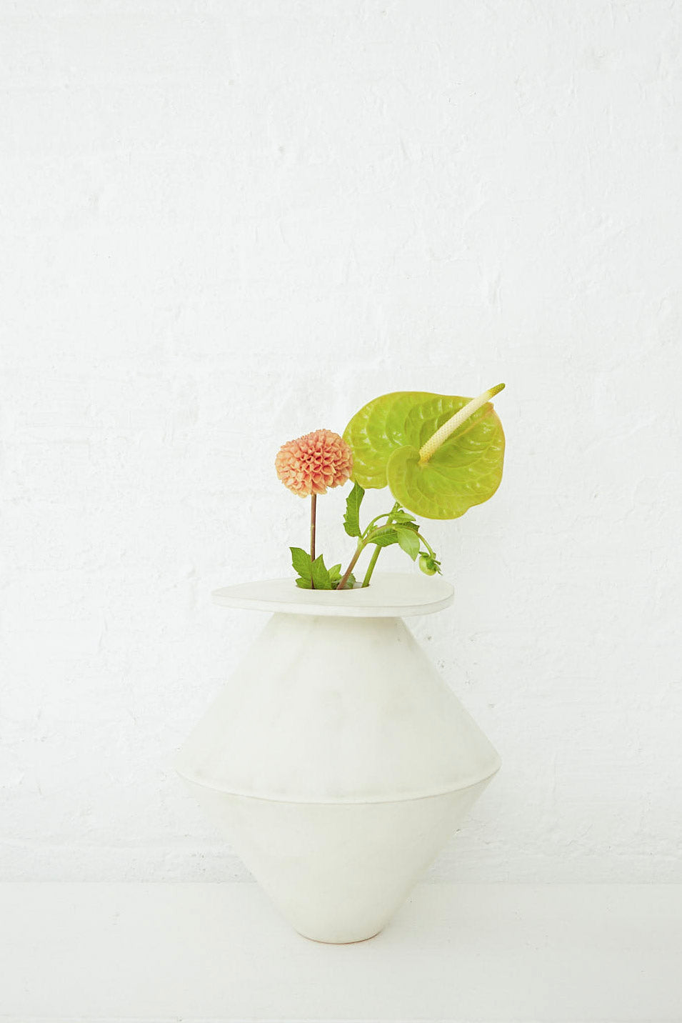 A Jumbo Diamond Vase in Cream by BZIPPY with a plant in it.