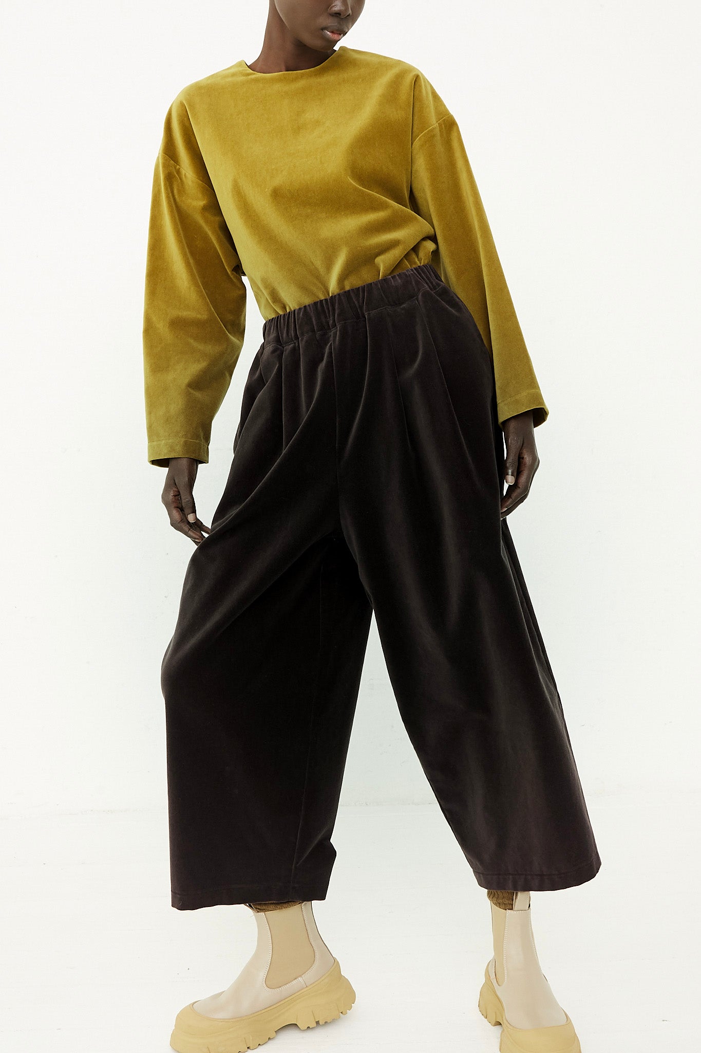 The model is wearing a yellow sweater and Cotton Velveteen Wide Pants with an elasticated waist by Black Crane.