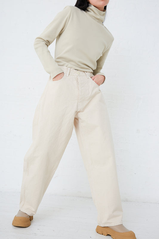 A woman wearing a turtle neck sweater and beige Jesse Kamm Organic Canvas California Wide pants in Natural with a relaxed fit.
