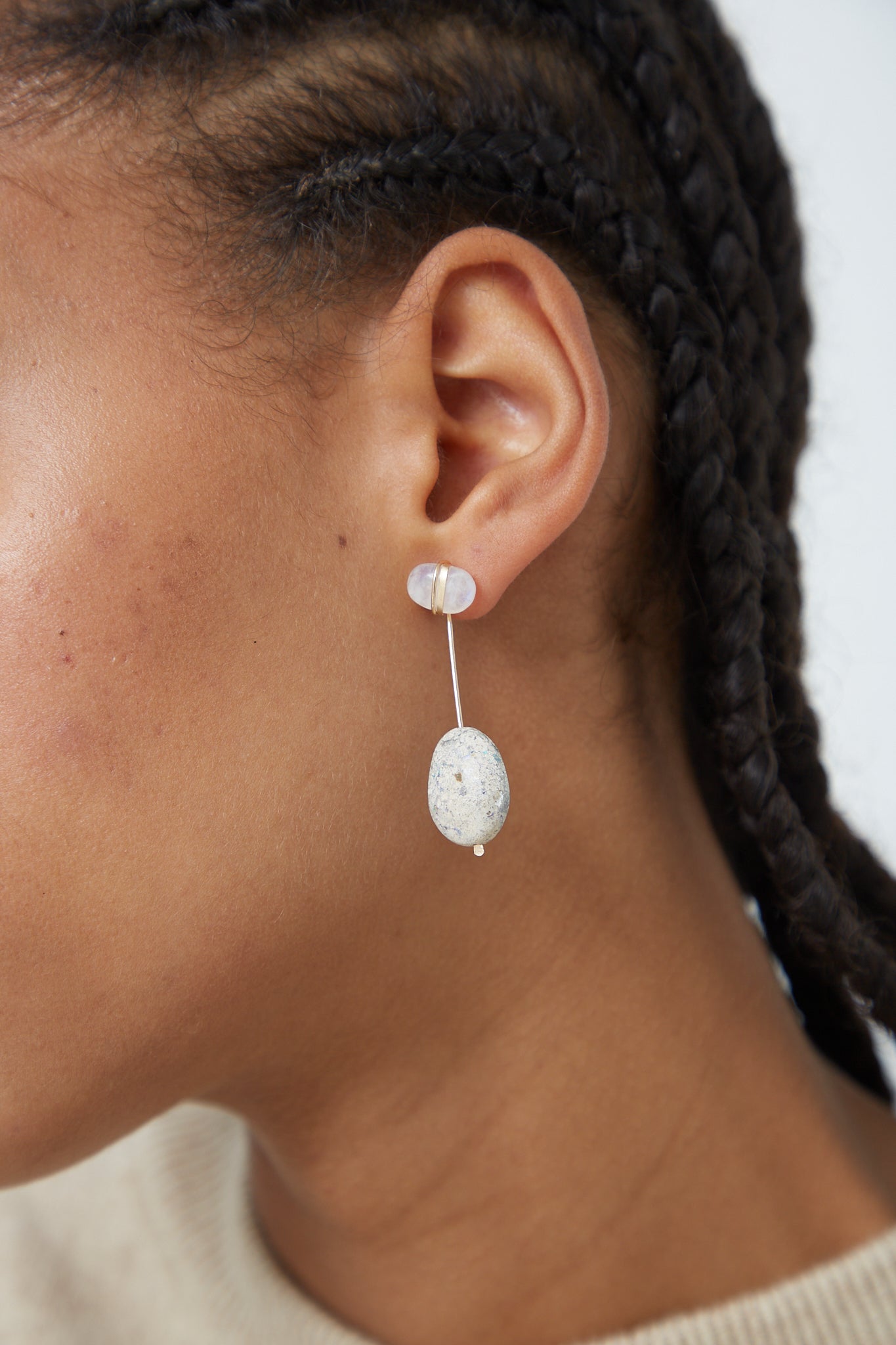 A woman wearing a pair of Mary MacGill Sculpture Earrings in Cottonwood I with a moonstone stone.