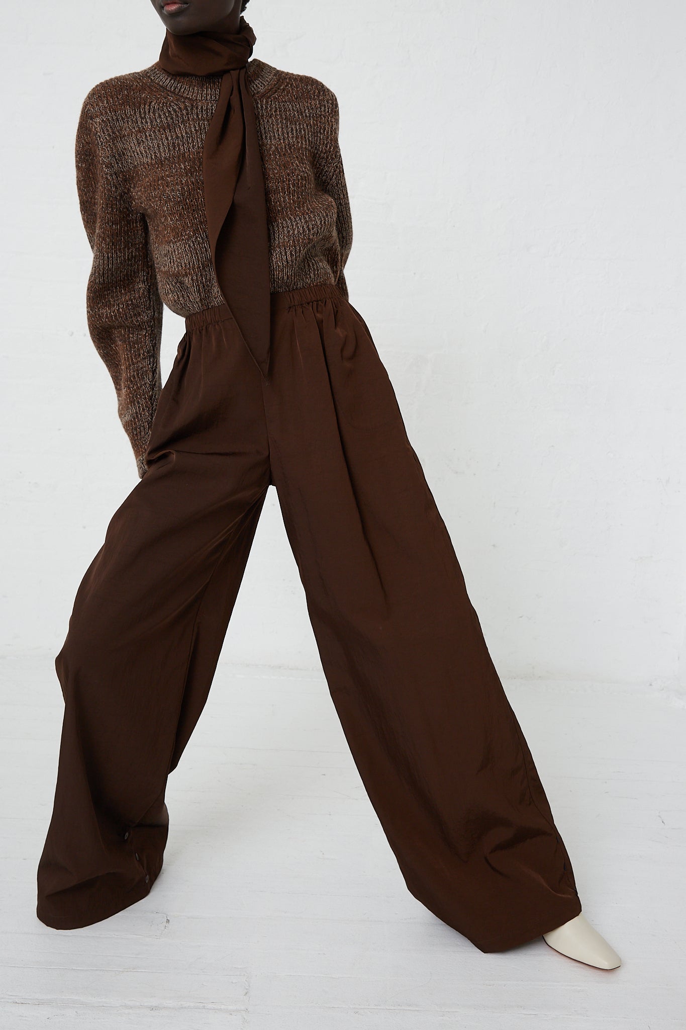 A woman wearing Large Drawstring Trousers in Choco by Veronique Leroy with an adjustable drawstring waist and a sweater.