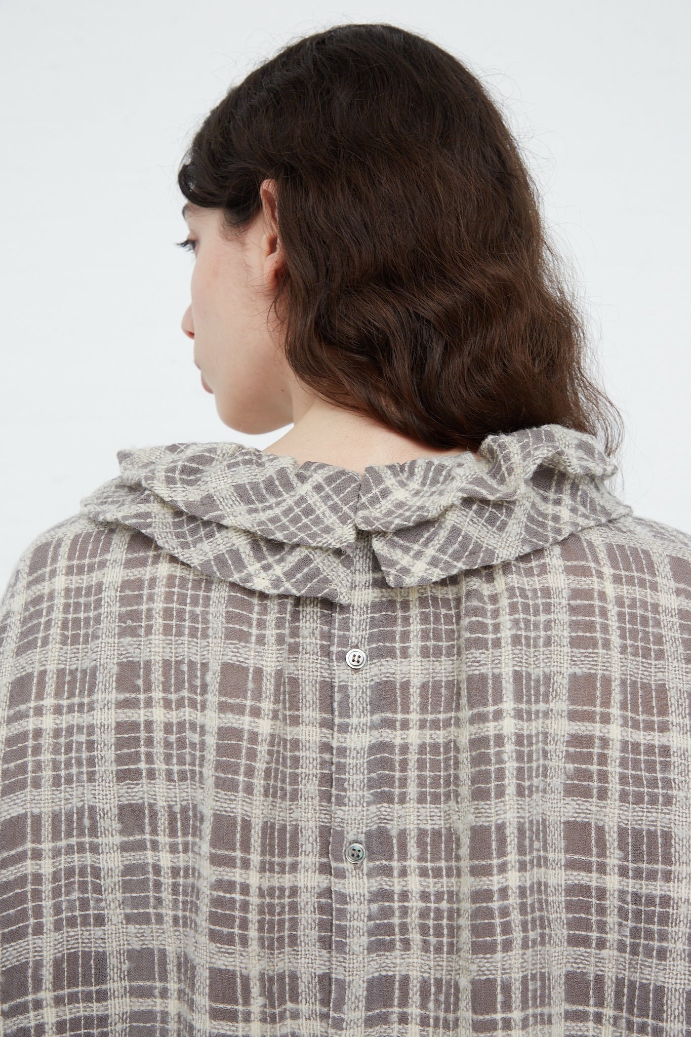 The back view of a woman wearing an Ichi Antiquités Wool Check Frill Dress in Mocha.