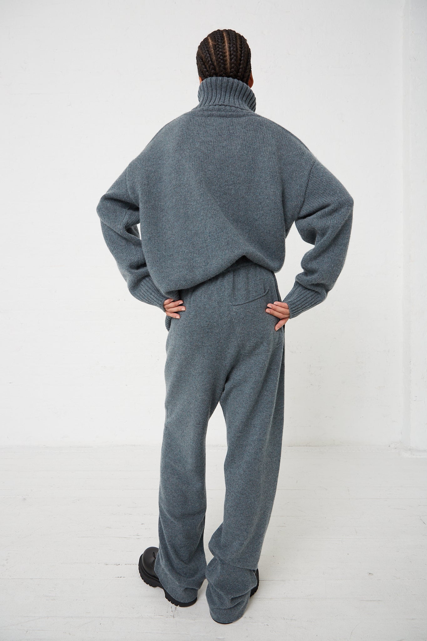 The back of a man in a Extreme Cashmere No. 320 Rush Trouser in Wave jumpsuit.