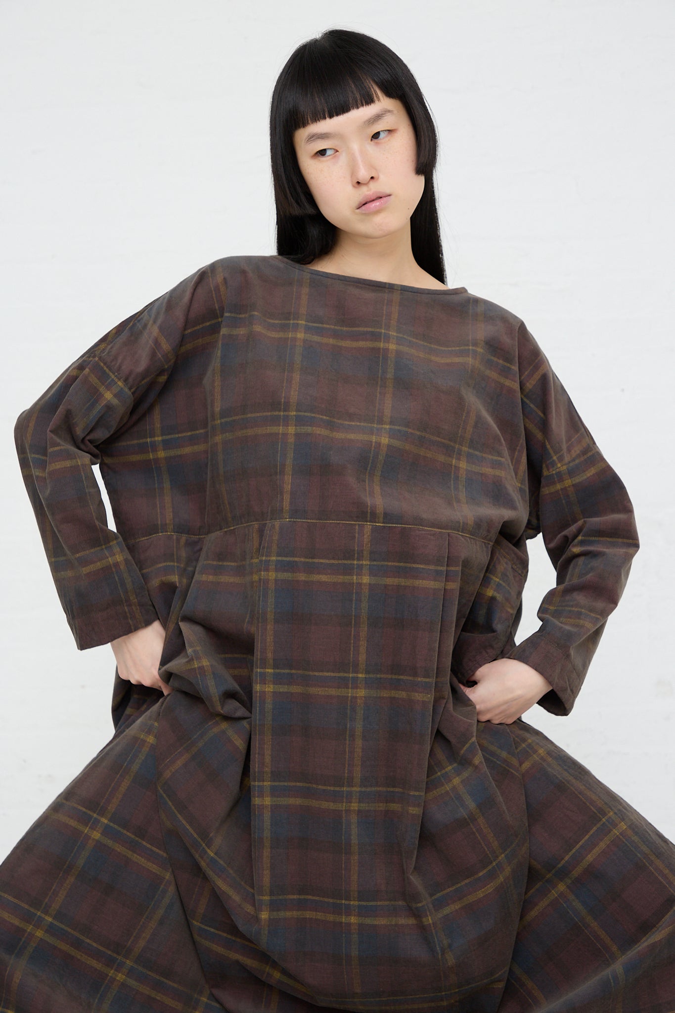 The model is wearing an Ichi woven brown plaid cotton dress.