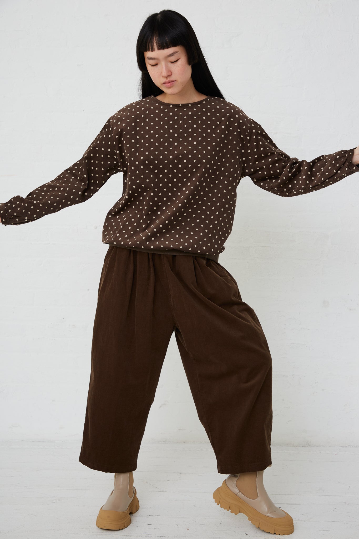A woman wearing a relaxed fit brown polka dot sweater and Ichi Cotton Pant in Brown.