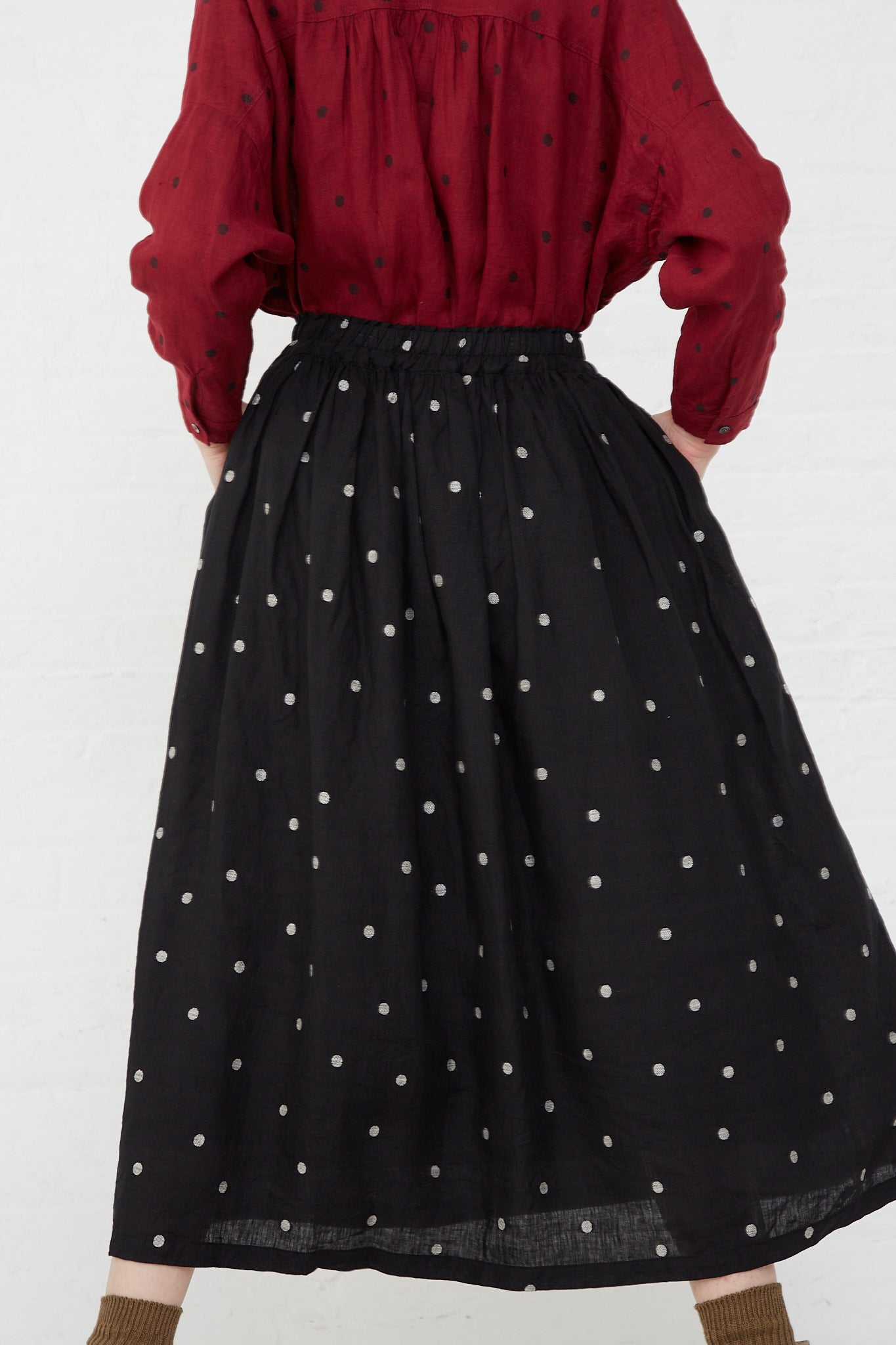 The back of a woman wearing an Ichi Antiquités Linen Dot Skirt in Black and Natural with an elasticated waist.