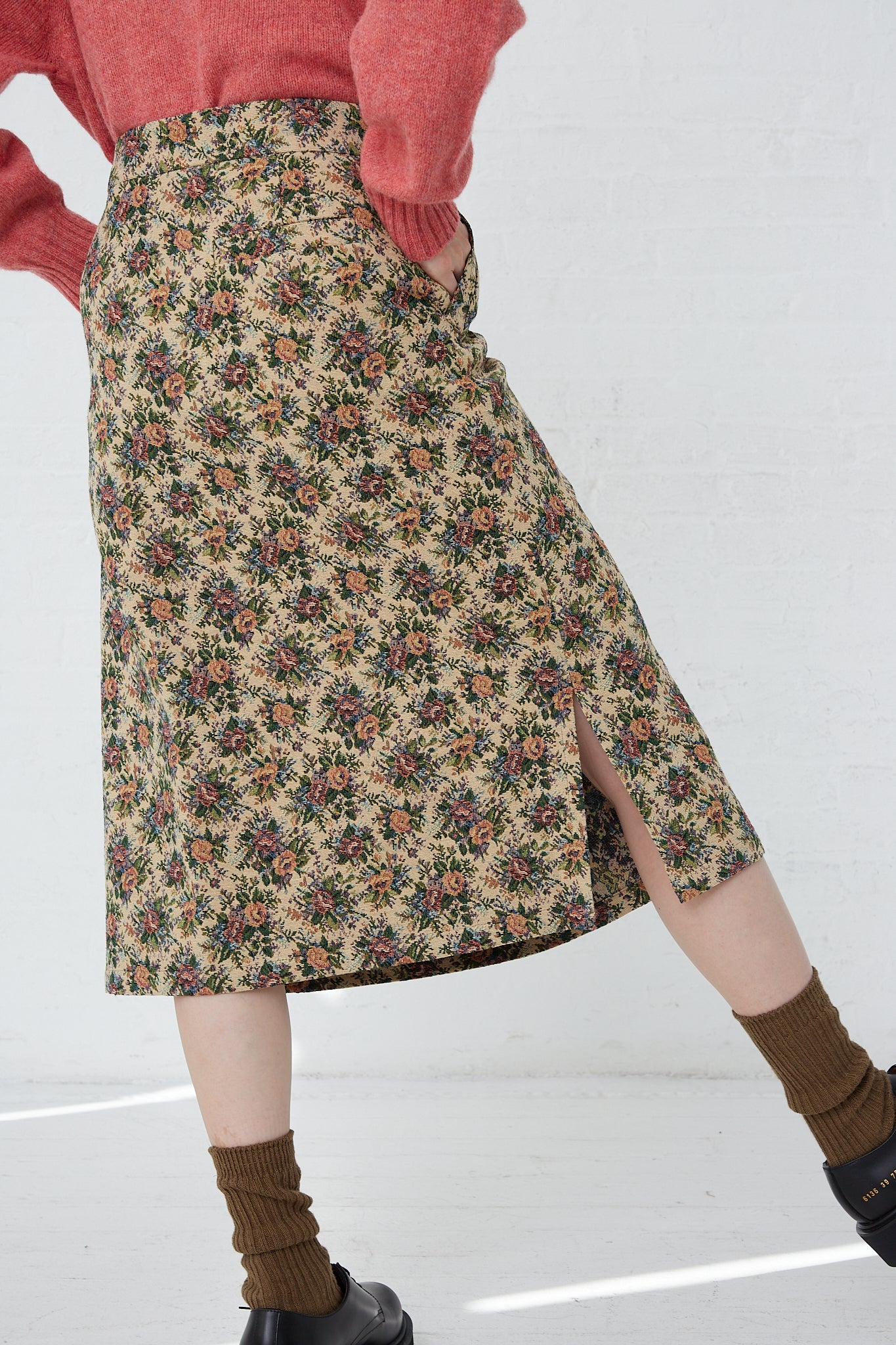 A woman wearing a Bless SMLXL Skirt No. 75 in Flower made of brocade cotton blend fabric.