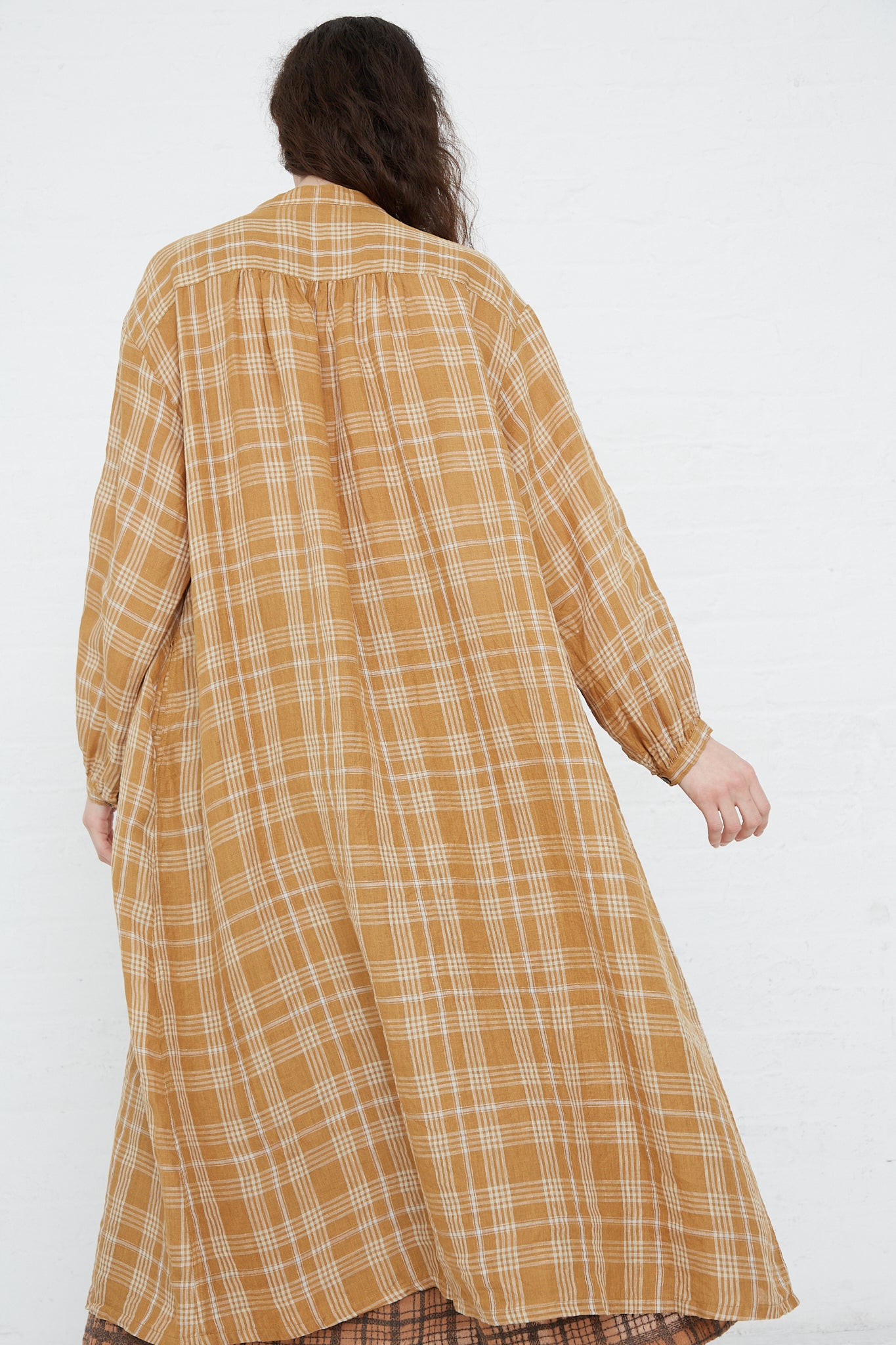 A woman wearing an Ichi Antiquités Linen Check Dress in Camel with a relaxed fit.