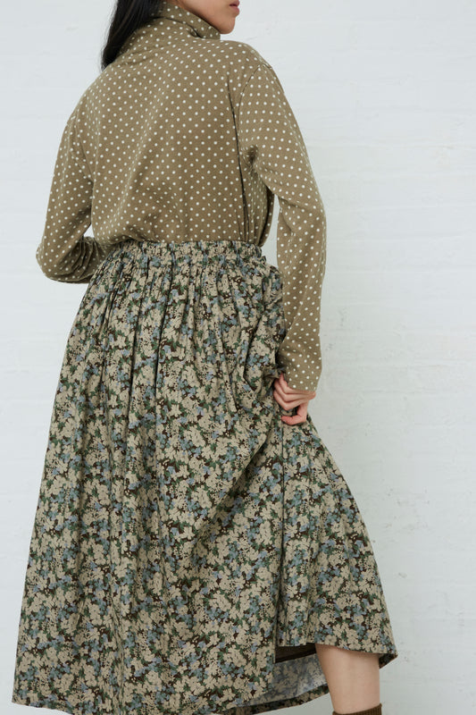 A woman wearing an Ichi mid-length Floral Skirt in Brown. Back view.