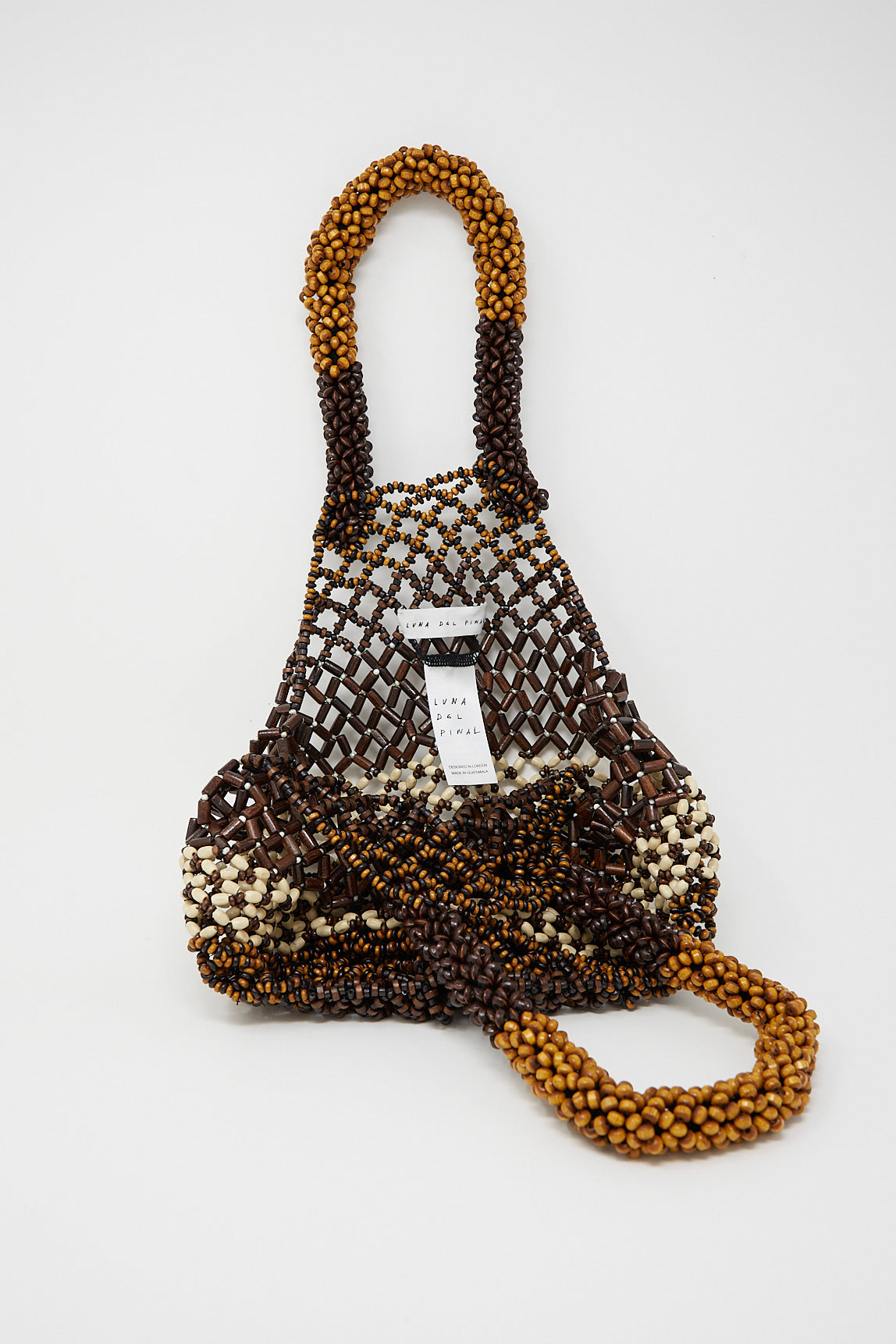 A Medium Wooden Beaded Bag in Bone Brown by Luna Del Pinal adorned with wooden beads on a white surface.