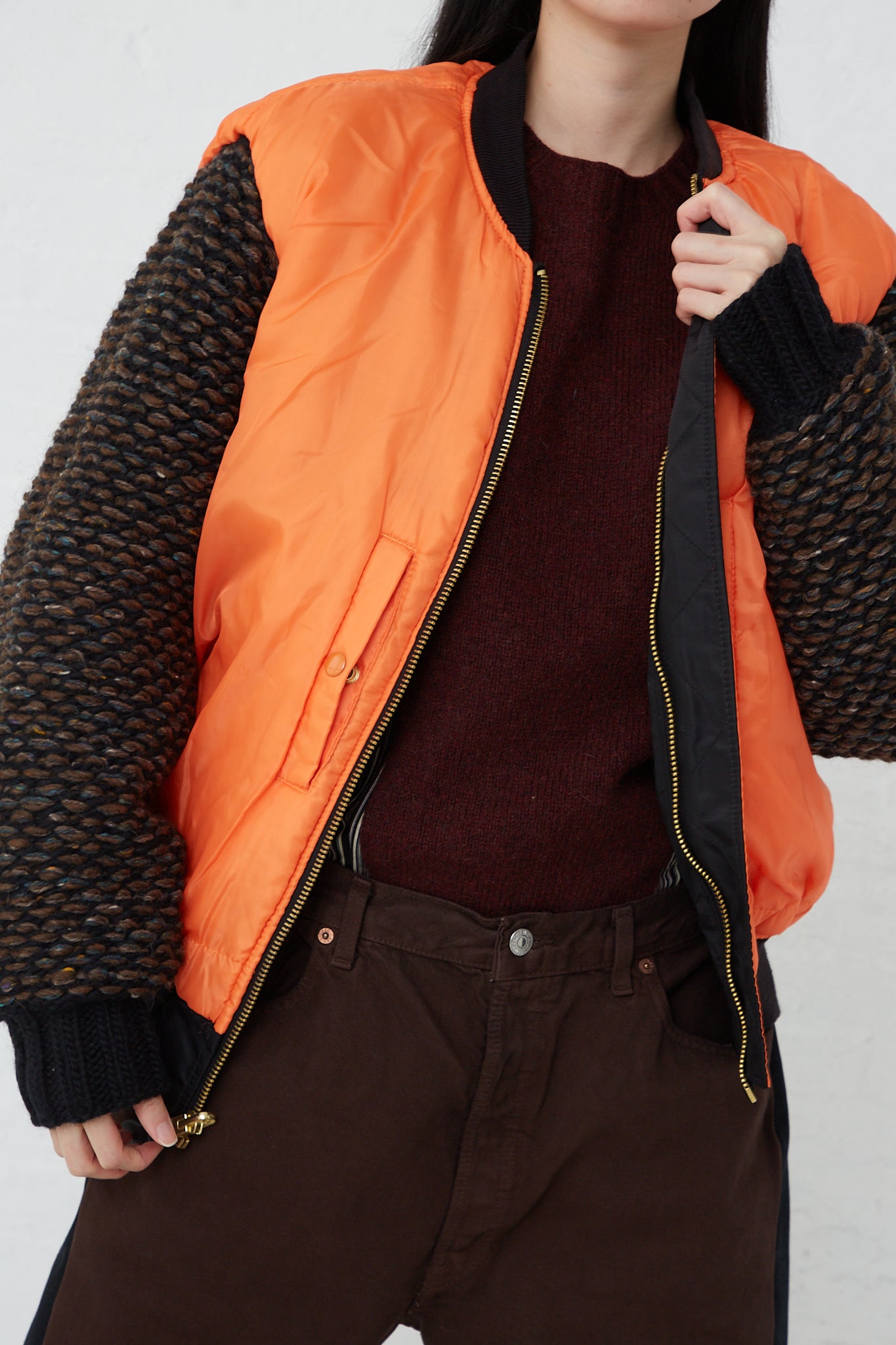 An oversized-fit woman wearing the Bless Sleeve Bomber No. 70 in Black, a nylon and wool blend bomber jacket.