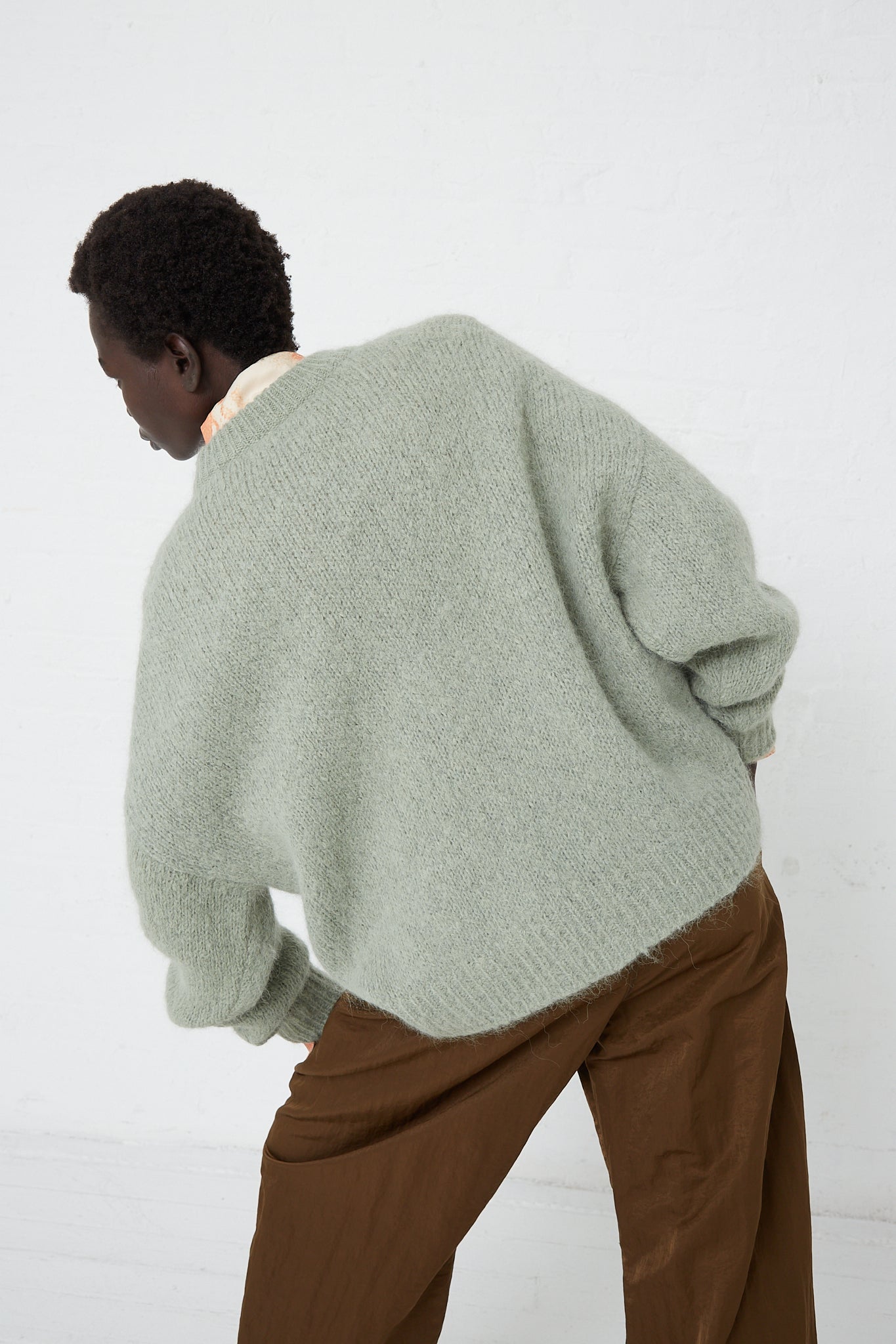 The model is wearing an Alpaca Blend Toni Sweater in Mint from Rejina Pyo.